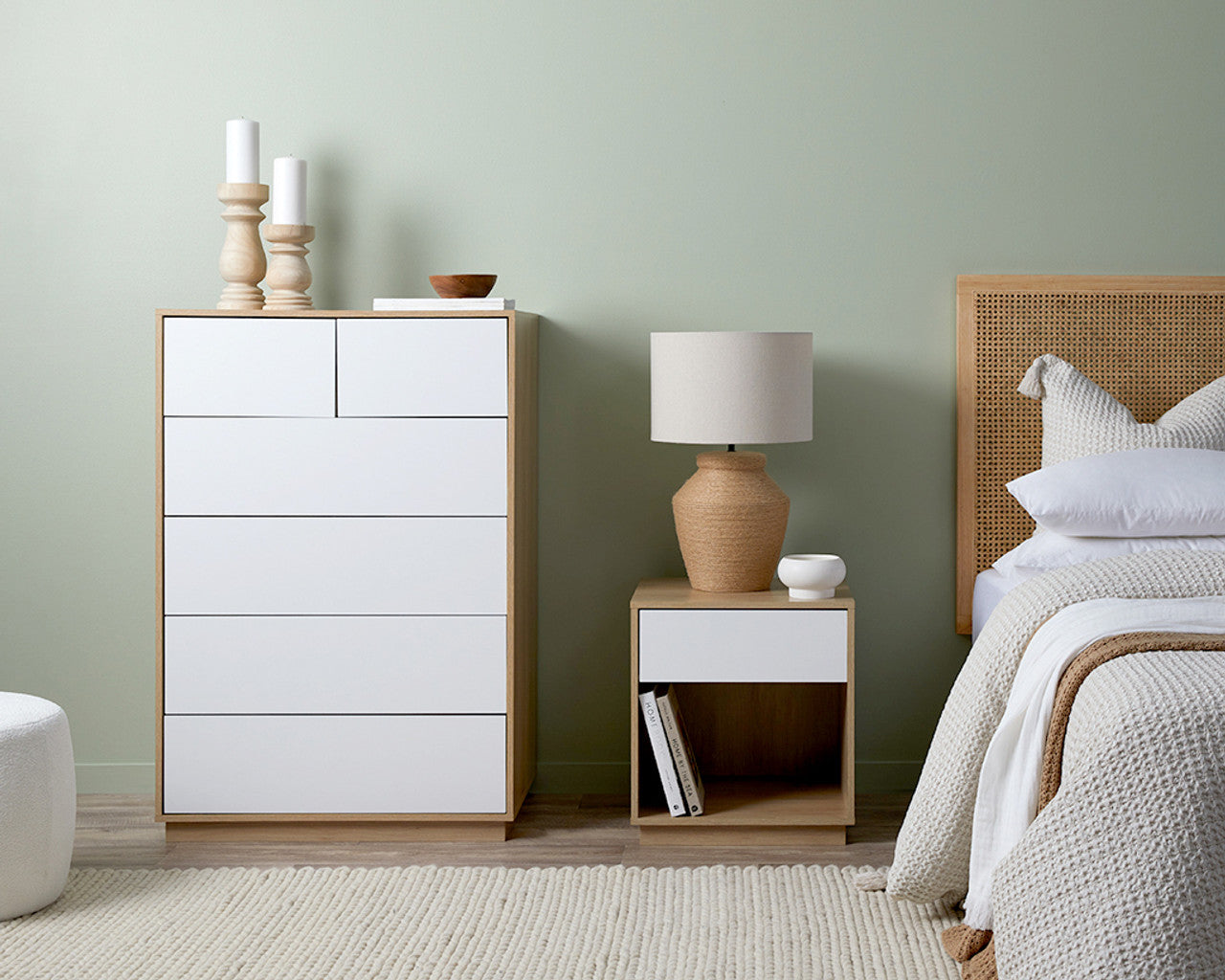 Imperial Homes coastal bedside pedestal next to bed with lamp, white drawers, and decorative candles in modern bedroom