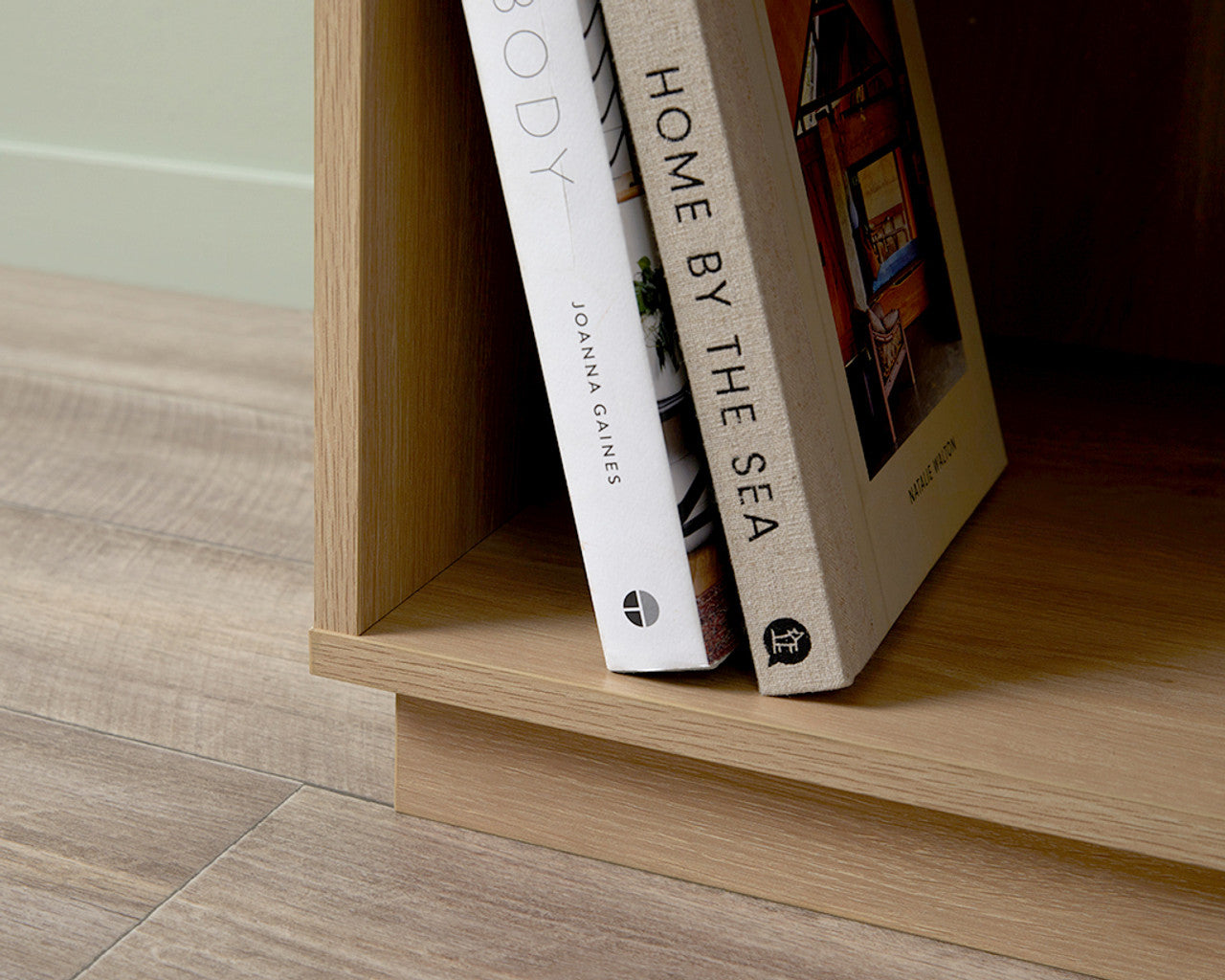 Close-up of coastal bedside pedestal wooden base with books on a light wood floor