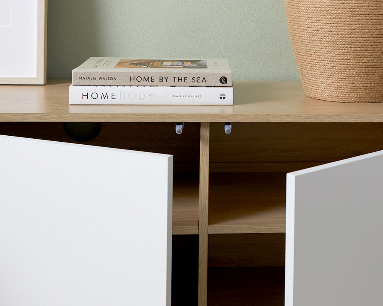 Imperial Homes coastal TV unit with white doors open showing interior shelves and decorative books on top