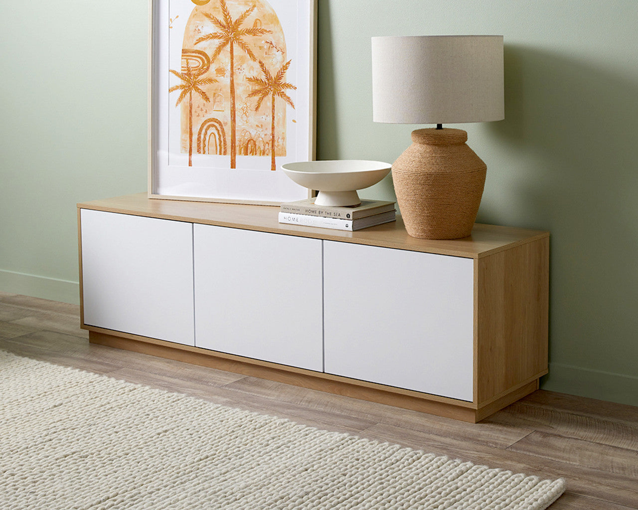Imperial Homes coastal TV unit with wood finish and white cabinet doors styled with lamp and artwork