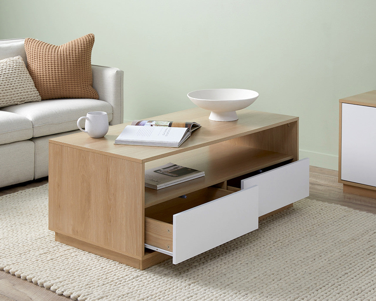 Imperial Homes modern minimalist coffee table with light wood finish and white drawers in a living room