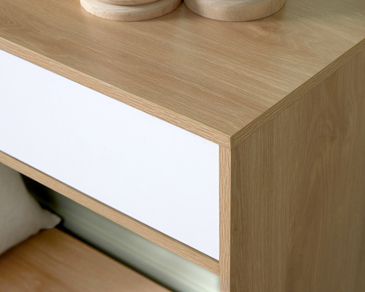Close-up view of Imperial Homes coastal console table corner featuring light wood and white drawer