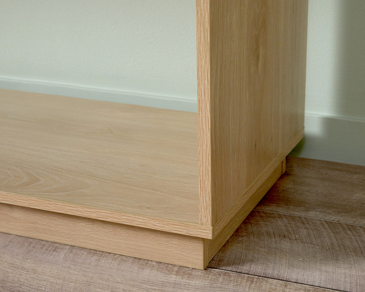 Close-up of light wood coastal console table corner showing smooth finish and craftsmanship