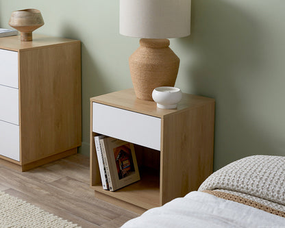 Imperial Homes coastal bedside pedestal with light wood frame and white drawer in a modern bedroom setup