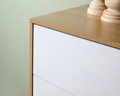 Close-up view of coastal tallboy chest of drawers with white drawer fronts and natural wood top finish