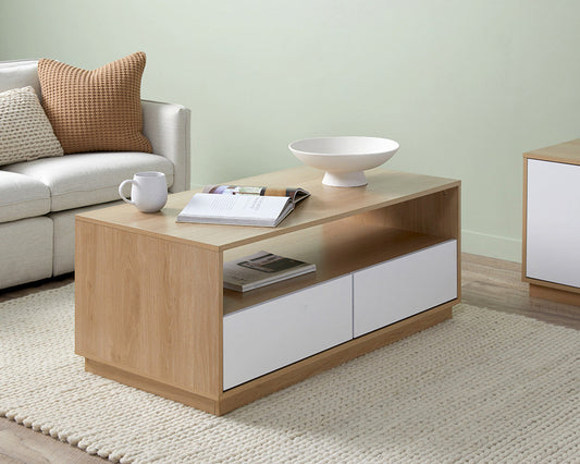 Imperial Homes modern minimalist coffee table in light wood with white drawers in living room setting