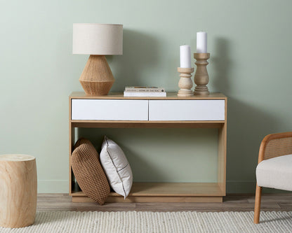 Coastal console table by Imperial Homes with two white drawers styled with lamp, candles, and decorative pillows